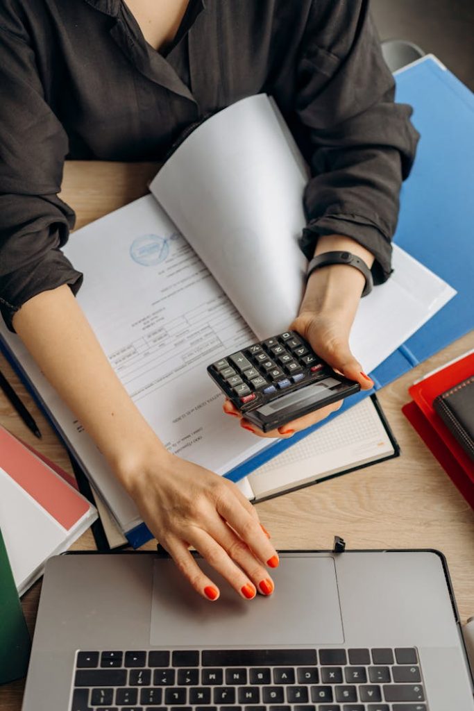 pexels-photo-8296981 Person Holding Black Calculator While Using Laptop